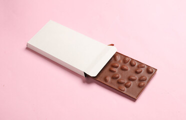 Mockup of white cardboard box with chocolate bar on pink background