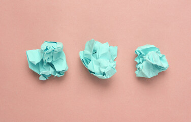 Pink crumpled sheets of paper on a light pink background. Minimal concept
