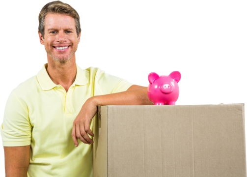 Portrait of smiling man by pink piggy bank on box