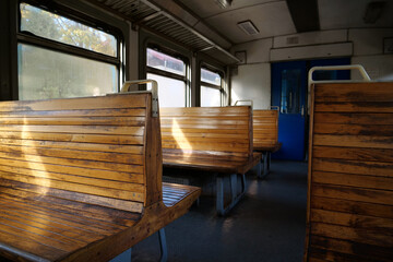 Old empty wagon of train. Wooden seats in an empty coach of train