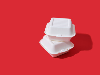 Burger take away boxes on red background with copy space