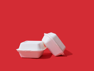 Burger take away boxes on red background with copy space