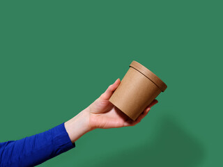 Female hand holding an ecological container for take away soup