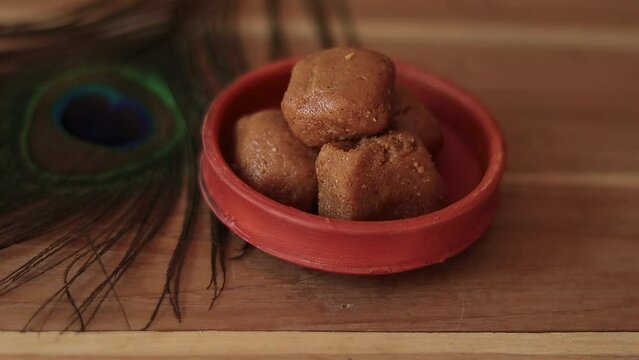Mathura ka peda is served on a clay plate with peacock feather during celebration of Krishna janmashtami. This traditional Indian sweet originated in mathura is made of khoya or Mawa, ghee and sugar.