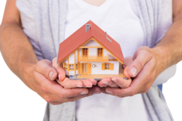 Couple holding a model house