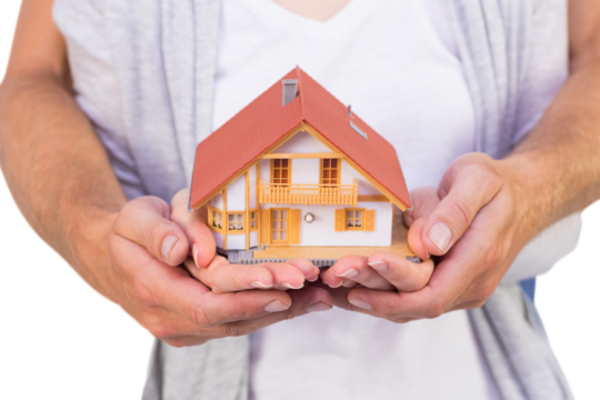 Couple holding a model house