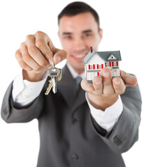 Miniature house and keys being presented by male estate agent