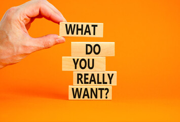 What do you really want symbol. Concept words What do you really want on wooden block. Beautiful orange table orange background. Businessman hand. Business what do you really want concept. Copy space.