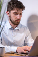 portrait d'un jeune employé de bureau ou homme d'affaires qui travaille devant son ordinateur...