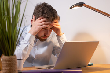 portrait d'un étudiant ou d'un employé de bureau fatigué et surmené assis devant son ordinateur...