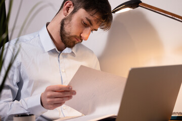 portrait d'un jeune employé de bureau ou homme d'affaires qui travaille assis dans son bureau...