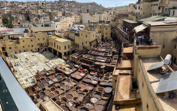Fes, Morocco, Africa: aerial view of the tannery where workers dye the leather in stone tubs arranged in a honeycomb pattern and filled with different colours, traditional and ancient jobs