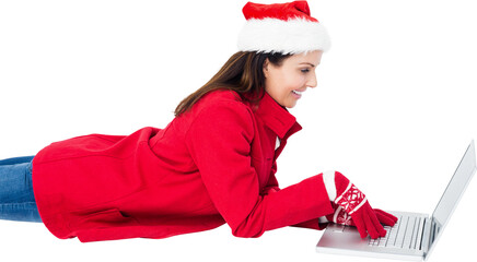 Brunette with santa hat lying on floor using laptop