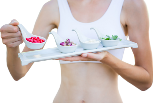 Fit woman holding plate with herbal medicine - Powered by Adobe