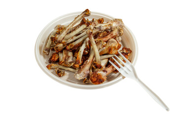 Bones from chicken wings in a disposable plate on the table. Leftovers. Cooked dog treat. Isolate on white.