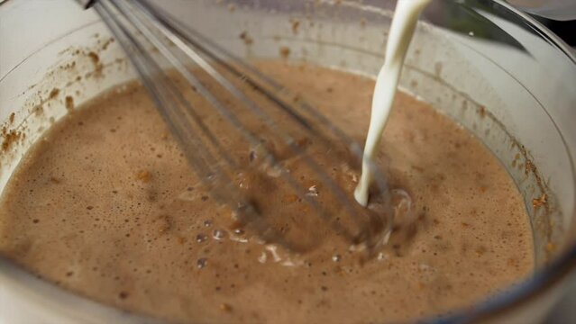 Close up chef melts milk and chocolate in the bowl. Bunet typical Piedmontese sweet preparation.Super slow motion 4K