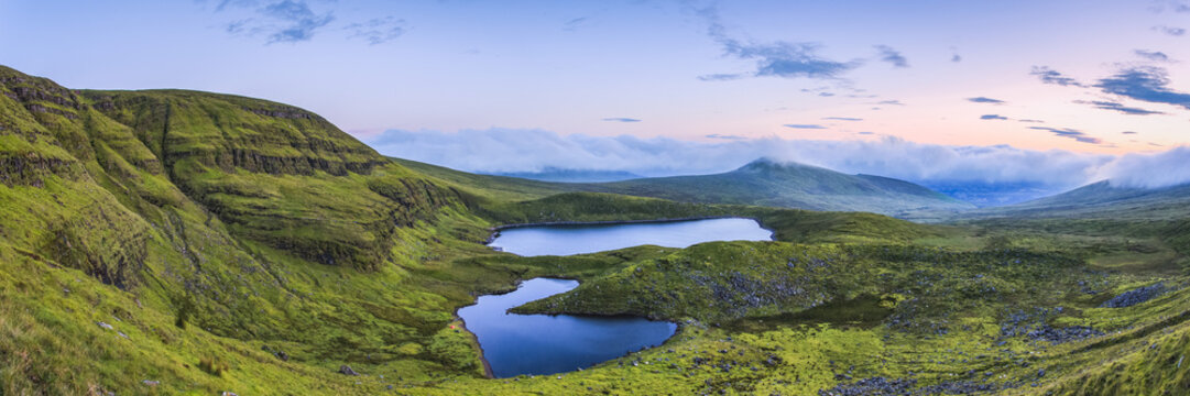 Panoramic view of two lakes in the Galty Mountains at dawn, panoramic stitched composite; County Limerick, Ireland