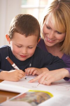 A Mother Doing Workbook Activities With Her Son
