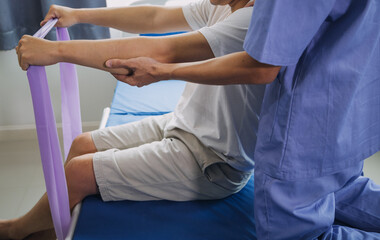 Obraz premium Doctor or Physiotherapist working examining treating injured arm of athlete male patient, stretching and exercise, Doing the Rehabilitation therapy pain in clinic.