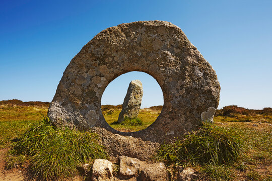View through the holed stone of the prehistoric Men-an-Tol standing stones near Penzance; Cornwall, England, Great Britain