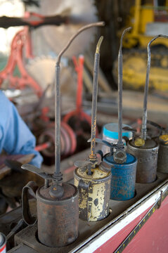 Old oil cans in a row on a shelf at a farm; Cortland, Nebraska, United States of America
