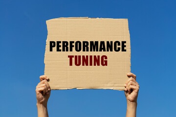 Performance tuning text on box paper held by 2 hands with isolated blue sky background. This...
