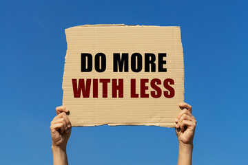 Do more with less text on box paper held by 2 hands with isolated blue sky background. This message...