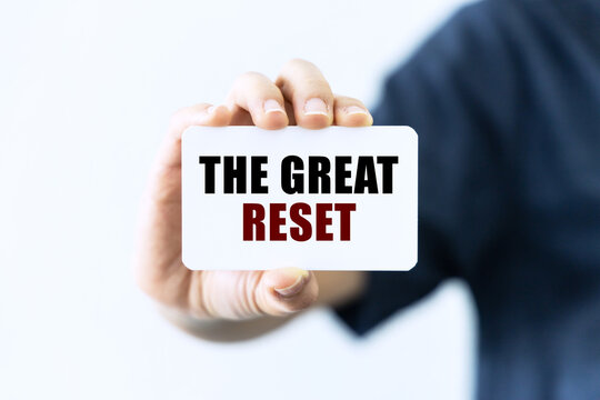 The great reset text on blank business card being held by a woman's hand with blurred background. Business concept about great reset.
