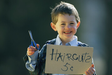 Young boy holds a sign advertising home haircuts; Lincoln, Nebraska, United States of America