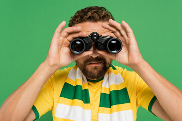 bearded man in striped scarf looking through binoculars during football match isolated on green.