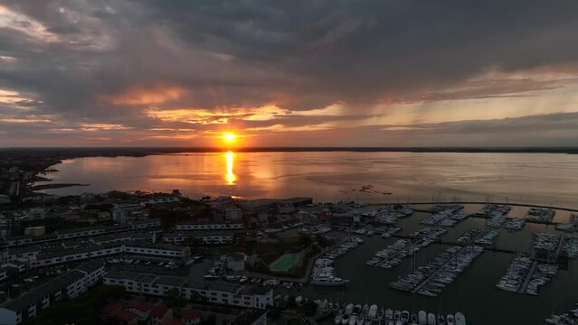 MONFALCONE, ITALY - APRIL, 2023: Sailing yacht moored off the coast Adriatic sea in Italy at sunset. Drone aerial view, cinematic frame. Romantic atmosphere. Calm and pacifying scene.