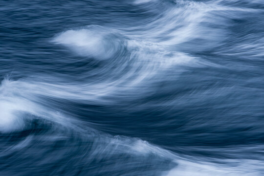 Close-up of wave patterns with motion in blue and white, viewed from a boat on Milford Sound in New Zealand; South Island, New Zealand