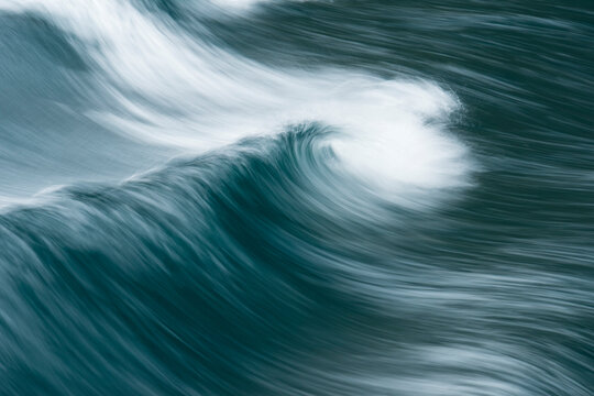 Close-up of wave patterns with motion in blue and white, viewed from a boat on Milford Sound in New Zealand; South Island, New Zealand