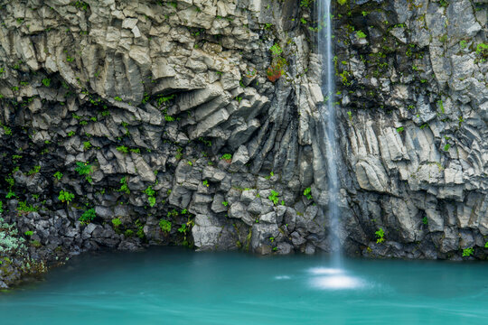Small waterfall cascades past basalt formations near Gullfoss waterfall in Iceland; Iceland