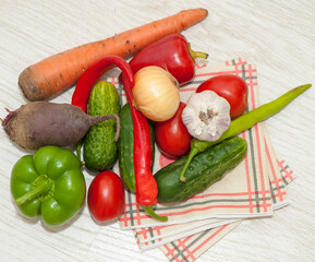 Vegetables carrots, beets, tomatoes, cucumbers, onions, peppers on a napkin