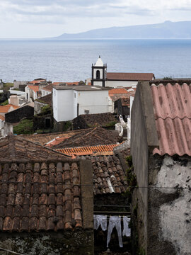 Clothes dry on a clothesline in the middle of the picturesque village of Corvo. On the horizon, the island of Flores. Corvo Island, Portugal.