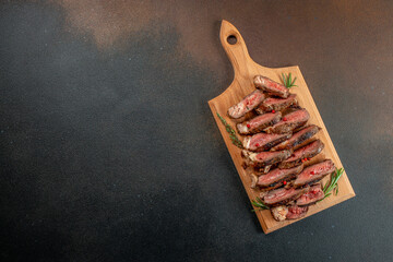 Sliced grilled beef barbecue Striploin steak on a wooden board, Restaurant menu, dieting, cookbook recipe top view