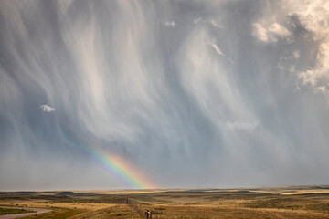 Major textured storm cloud unloading rain and hail but sharing a wonderful rainbow near Chugwater, Wyoming, USA; Wyoming, United States of America