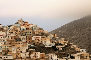 view of Olympos town with colourful buildings on Karpathos island, Greece with clouds descending onto the mountain