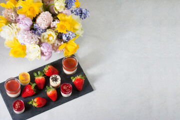 Top view of Mini mousse dessert on table with fruits and spring flowers.