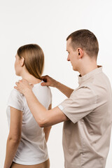Movement assessment or joint mobilization. Muscle release. Orthopedic traumatologist examines head and neck of patient and checks mobility of movements on white background.