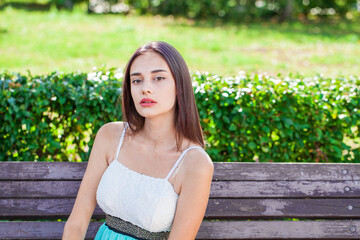 Fototapeta premium Portrait of a young beautiful brunette girl in summer park