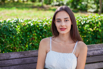 Portrait of a young beautiful brunette girl in summer park