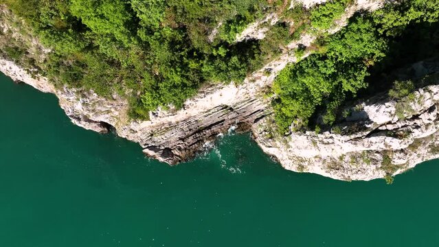 MONFALCONE, ITALY - APRIL, 2023: Sailing yacht moored off the coast Adriatic sea in Italy at sunny day. Drone aerial view, cinematic frame. Romantic atmosphere. Calm and pacifying scene.