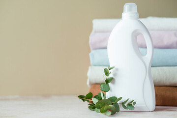 Mockup of a white plastic bottle with handle with for gel or liquid powder, gel, for place for design presentation with a branch of eucalyptus.