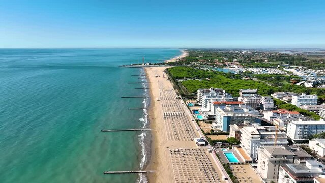 LIDO DI JESOLO, ITALY - APRIL, 2023: Aerial drone view of the beach at Adriatic sea coastline in Italy, Europe during summer. Sun loungers and umbrellas by the sea from above.