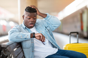 Stressed Black Man Late For Train, Checking Time On Wristwatch