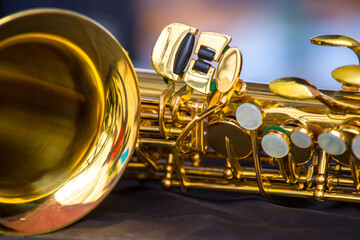 a fragment of a golden saxophone on a blurred background