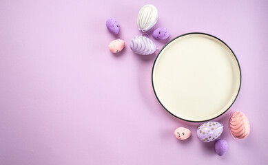 Obraz na płótnie Canvas Easter eggs on plate purple background. Happy Easter holiday concept