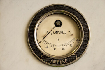 An antique non-functioning ammeter hangs on the wall as an element of decor